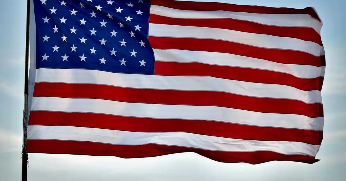The American flag flying against a blue sky